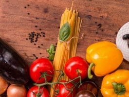 Ernährungsberatung: Verschiedene Gemüsesorten und Nudeln auf einem Holztisch.