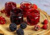 Gelierzucker – verschiedenen Sorten Beerenmarmelade in Gläsern auf einer Holzscheibe