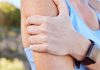 Muskelkater – Frau greift sich an den schmerzenden Oberarm