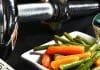 Sport und Ernährung: Hantel, Maßband und ein Teller mit Gemüse