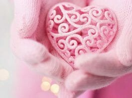 Whatsapp Valentinstagsgrüße – Frau hält rosa Herz in beiden Händen